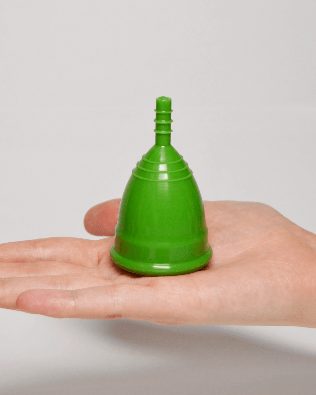 Зеленая менструальная чаша OnlyCup на ладони