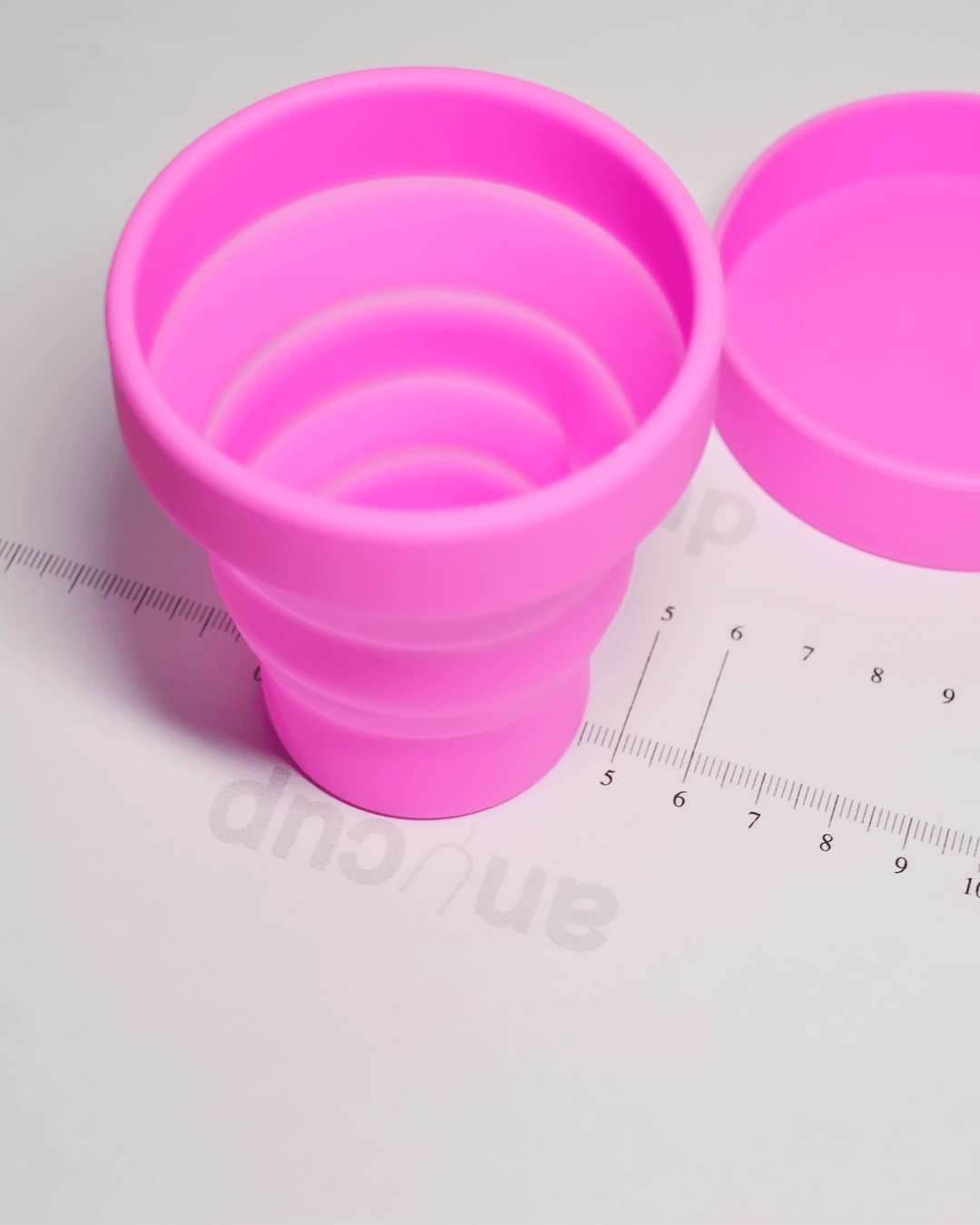 Розовый стакан для стерилизации менструальной чаши в разложенном виде